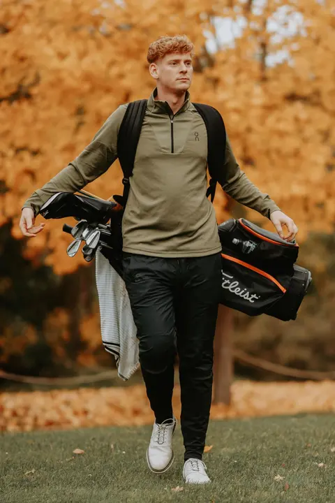 Richard Verpeléti, PGA Professional des Golfclub Mahlow, mit Golfbag auf dem Fairway