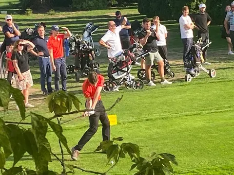 Spieler beim Abschlag während der Clubmeisterschaft 2022, im Hintergrund Zuschauer mit Trolleys