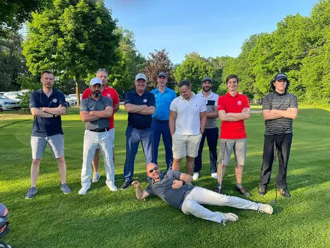 Herrenmannschaft des Golfclub Mahlow auf dem Grün, ein Spieler liegt scherzhaft vor der Gruppe